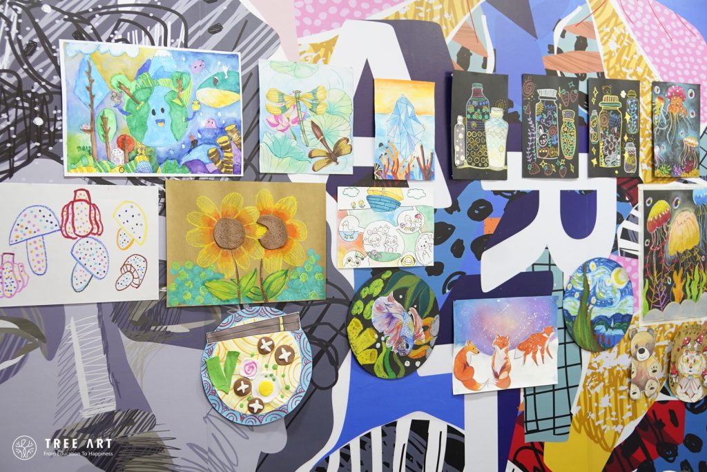 Wall display of student artwork on an environmental protection theme, showing a variety of paintings and mixed-media pieces