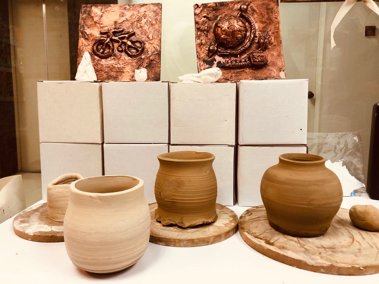 Hand-thrown clay pots and copper-relief plaques made by TREE ART students