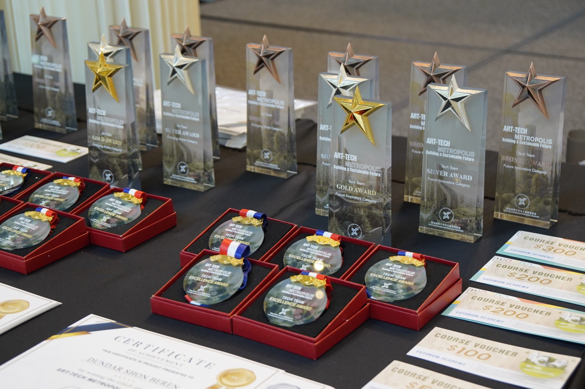 Rows of gold and silver star trophies lined up on the awards table