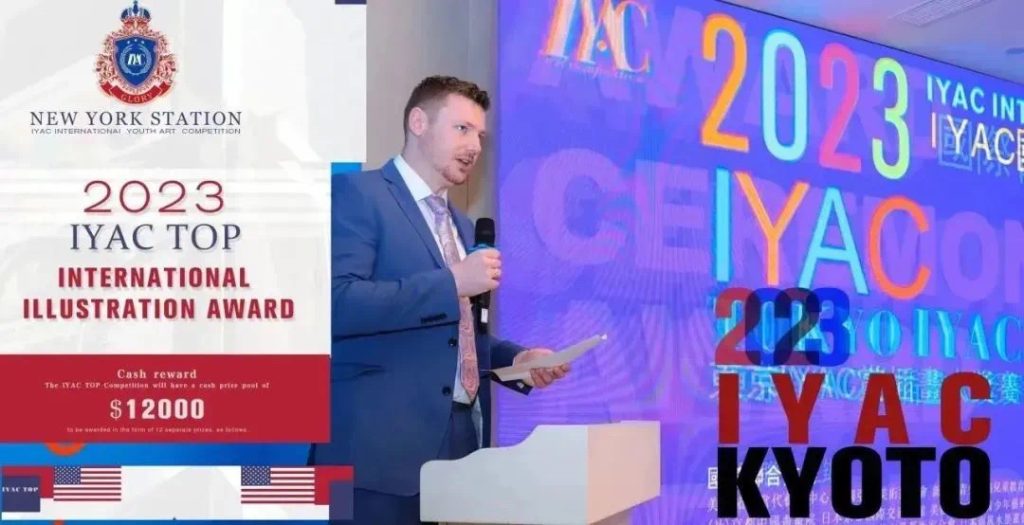 A speaker presenting the 2023 IYAC Top International Illustration Award at a podium, with the IYAC Kyoto 2023 branding shown on the screen behind him