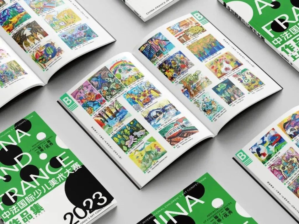 Printed "China and France 2023" art collection books displaying pages of children's winning artworks