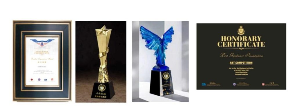 A framed honorary certificate, a gold star trophy, a blue crystal wing-shaped trophy and a black Honorary Certificate award card