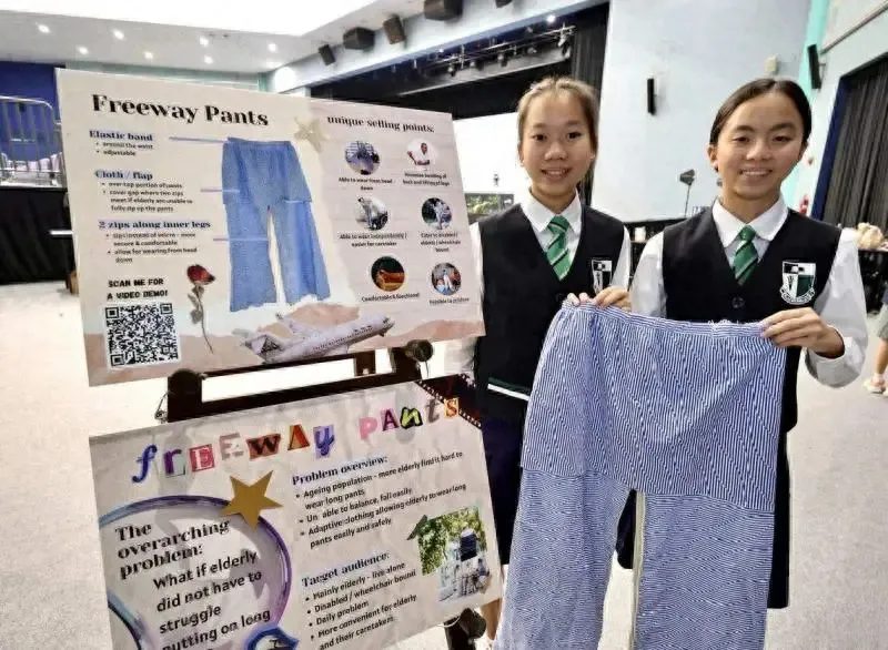 Two Raffles Girls' School students presenting their Freeway Pants invention, designed to help elderly wearers put on trousers without bending or lifting their legs