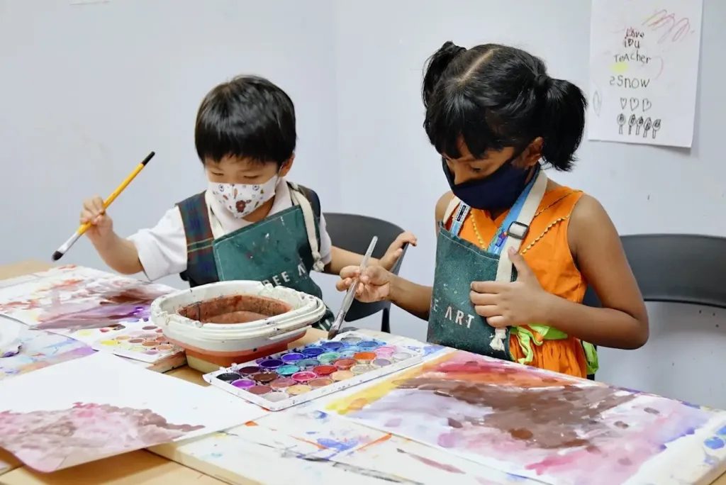 Children taking part in an age-appropriate art activity in a group class setting