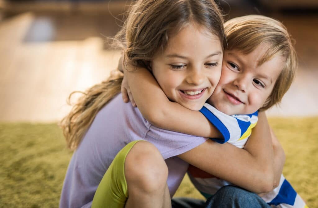 Two children hugging and smiling warmly, reflecting the emotional connection nurtured through art