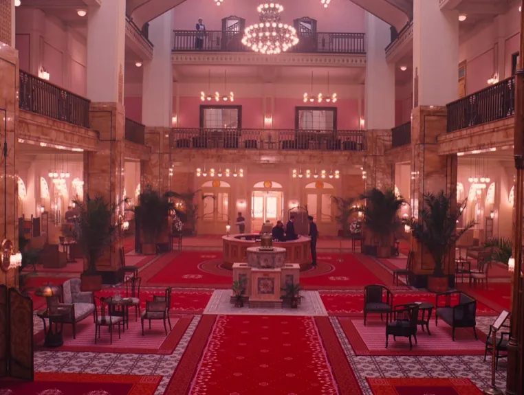 Symmetrically framed still from The Grand Budapest Hotel in the film's signature pastel palette