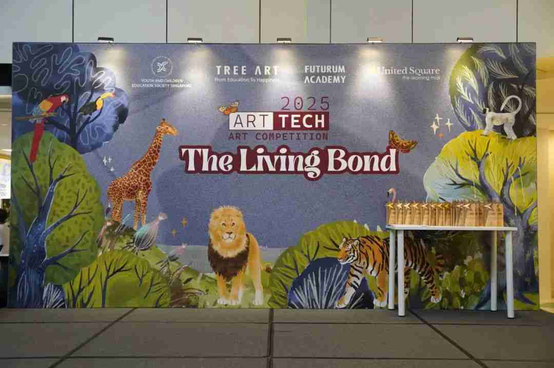 Photo of the 2025 ART TECH "The Living Bond" event backdrop at United Square, decorated with jungle animal illustrations, with a row of trophies displayed on a table in front