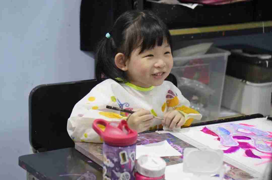 A smiling child painting at a TreeArt art studio