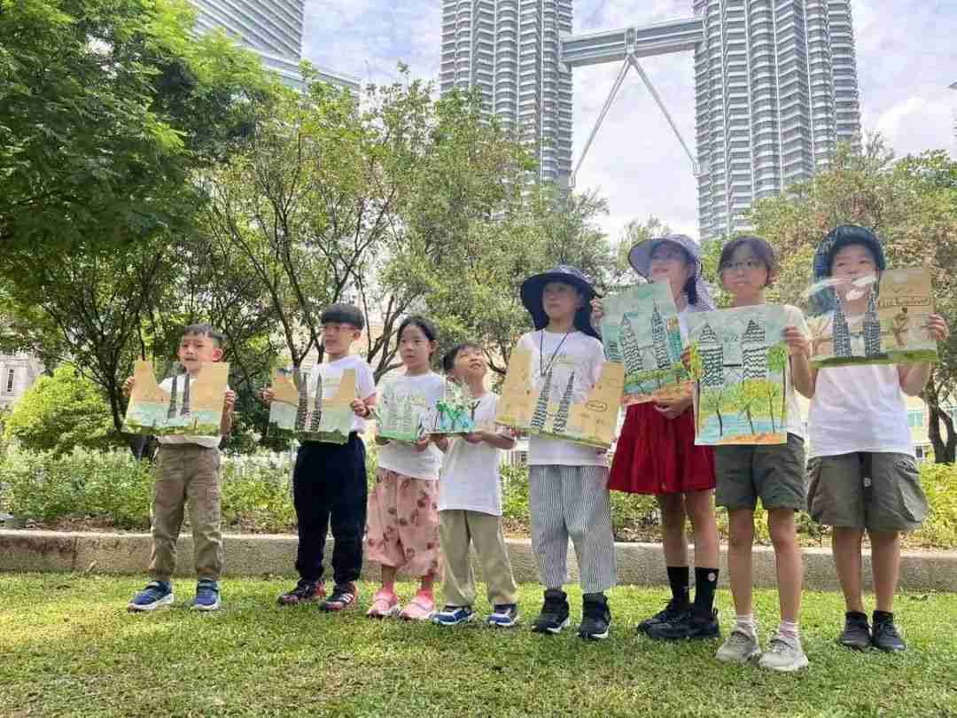 Children holding their sketches of the Petronas Twin Towers in front of the landmark