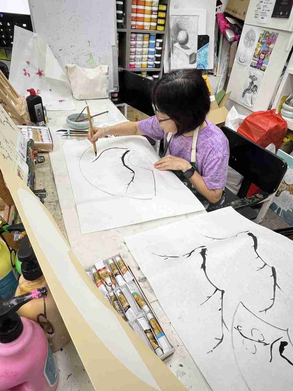 Adult student practising Chinese ink brushwork on rice paper