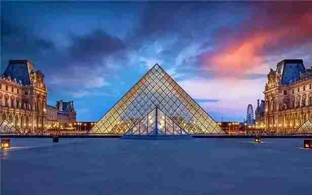 The Louvre Museum and its glass pyramid entrance at dusk