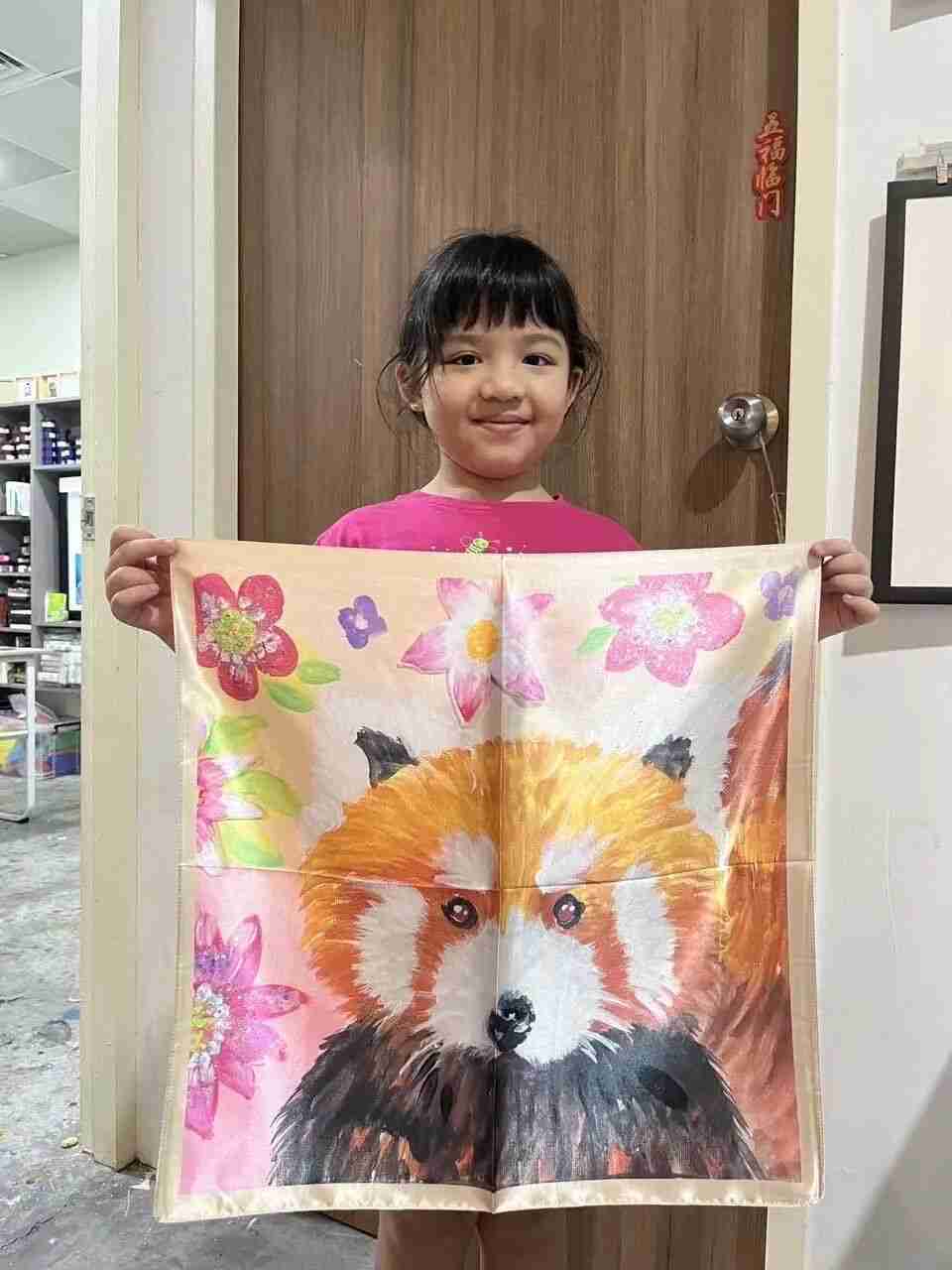Young TREE ART student holding up a finished silk scarf design