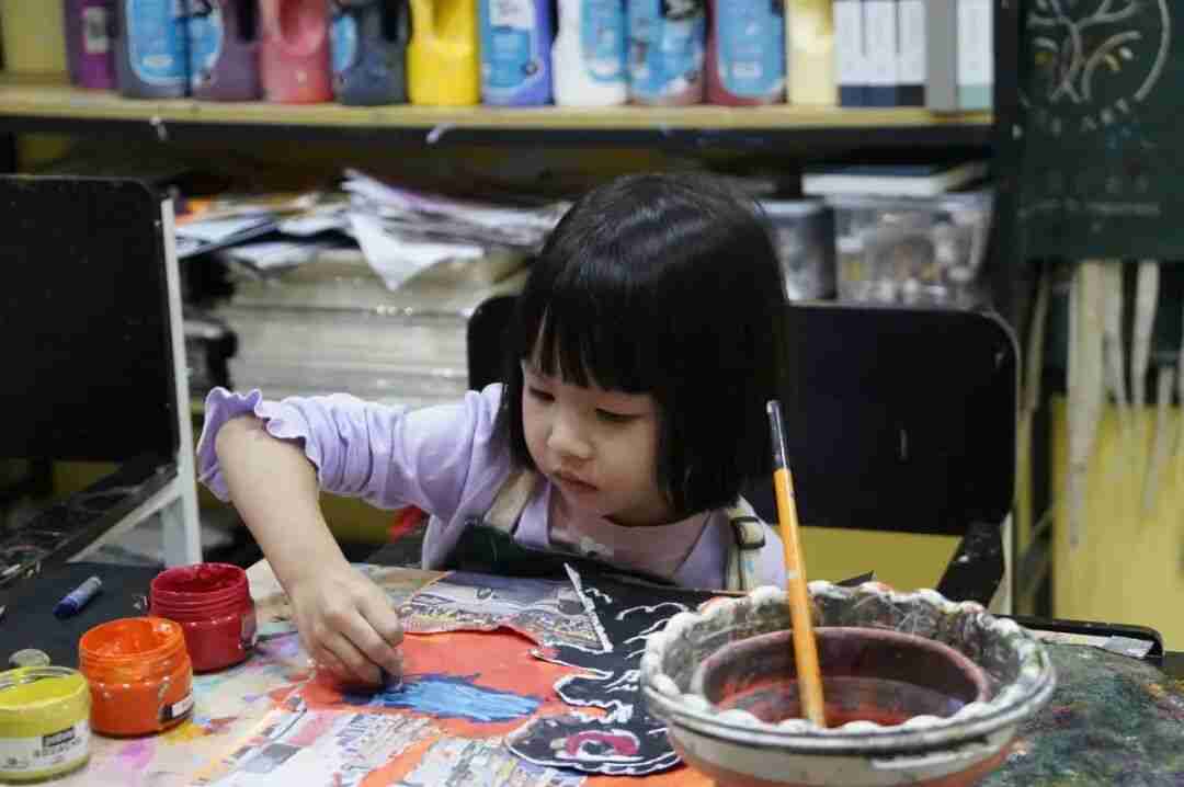 A young artist adding colour to a painting during a TreeArt class