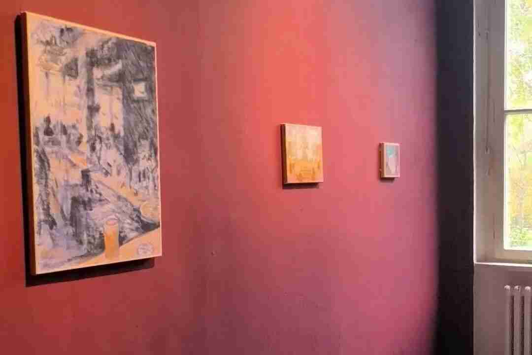 Paintings from the Asia Focus section hung on a deep red gallery wall near a window