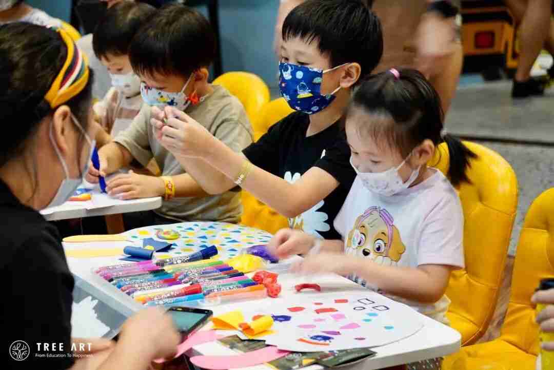 A young artist mixing colours while painting during a TreeArt class