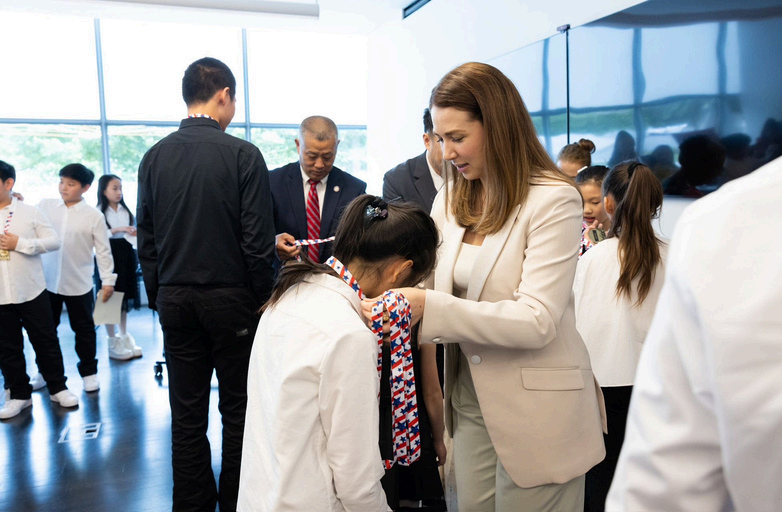 An adult presenting a medal to a child at an award ceremony