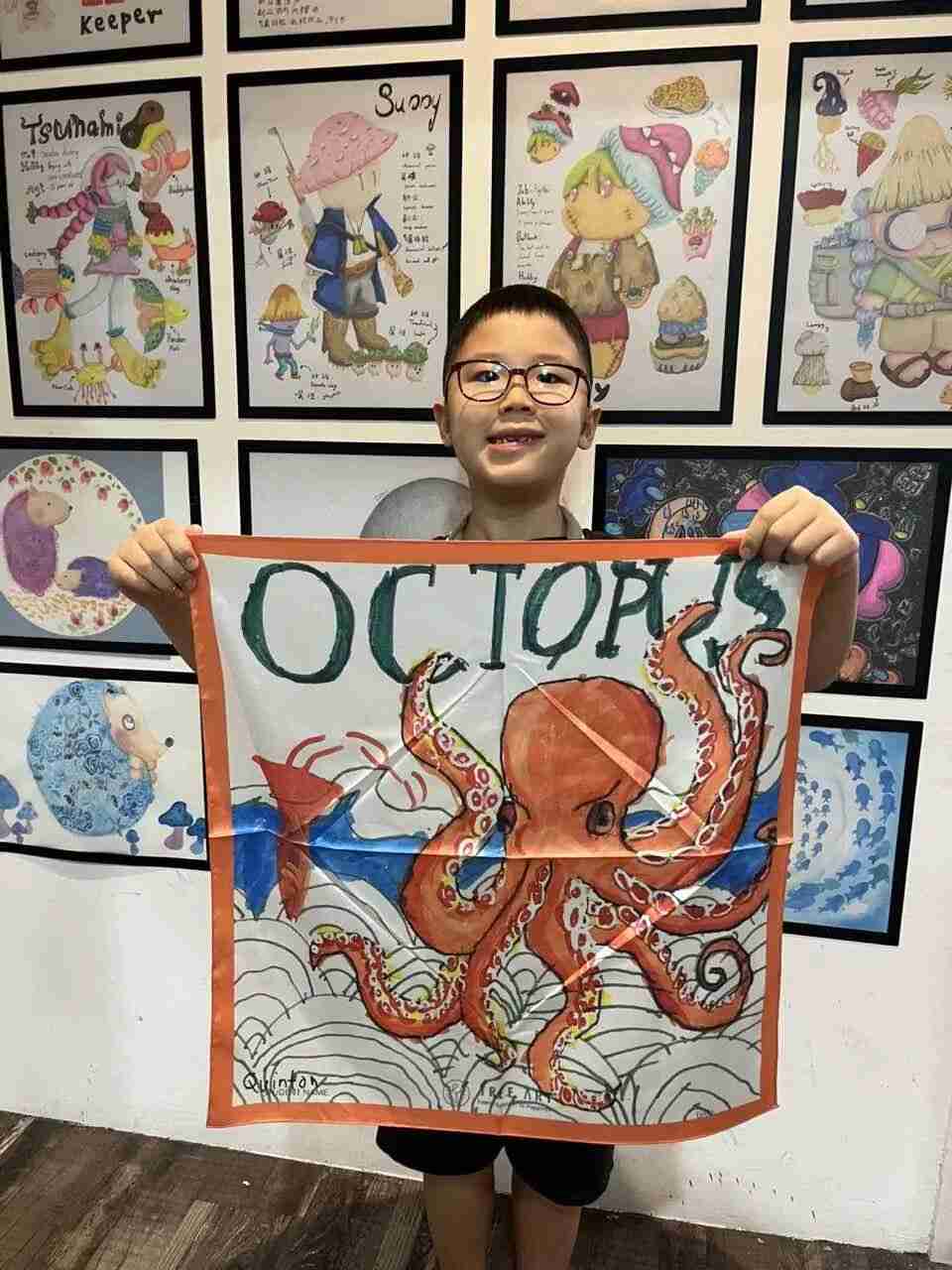 Child displaying the silk scarf they designed at TREE ART