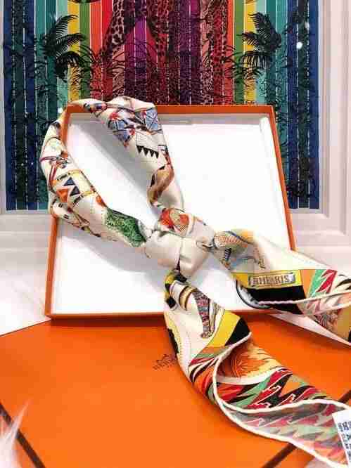 Colorful Hermès silk scarf tied atop its signature orange gift box