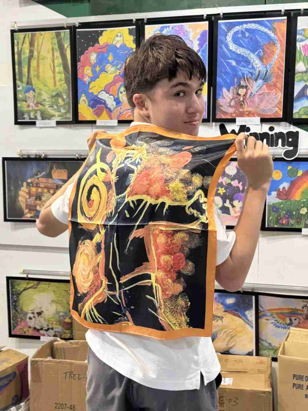Child sketching a pattern design for a silk scarf in class