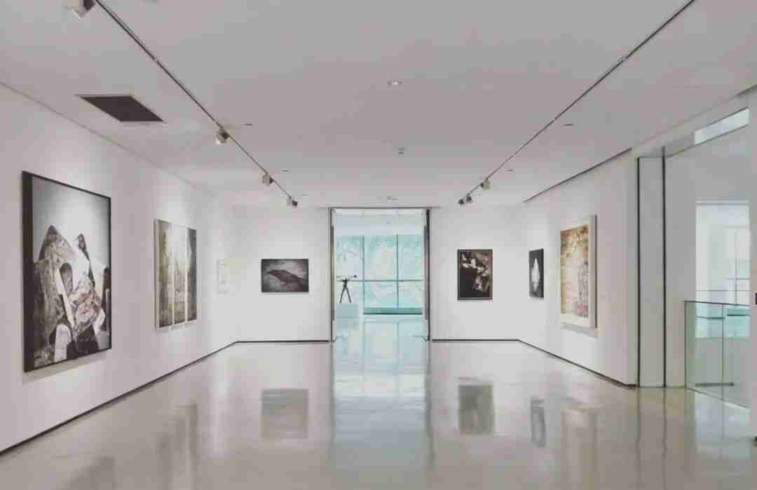 Interior view of a white-walled gallery space with framed artworks on display
