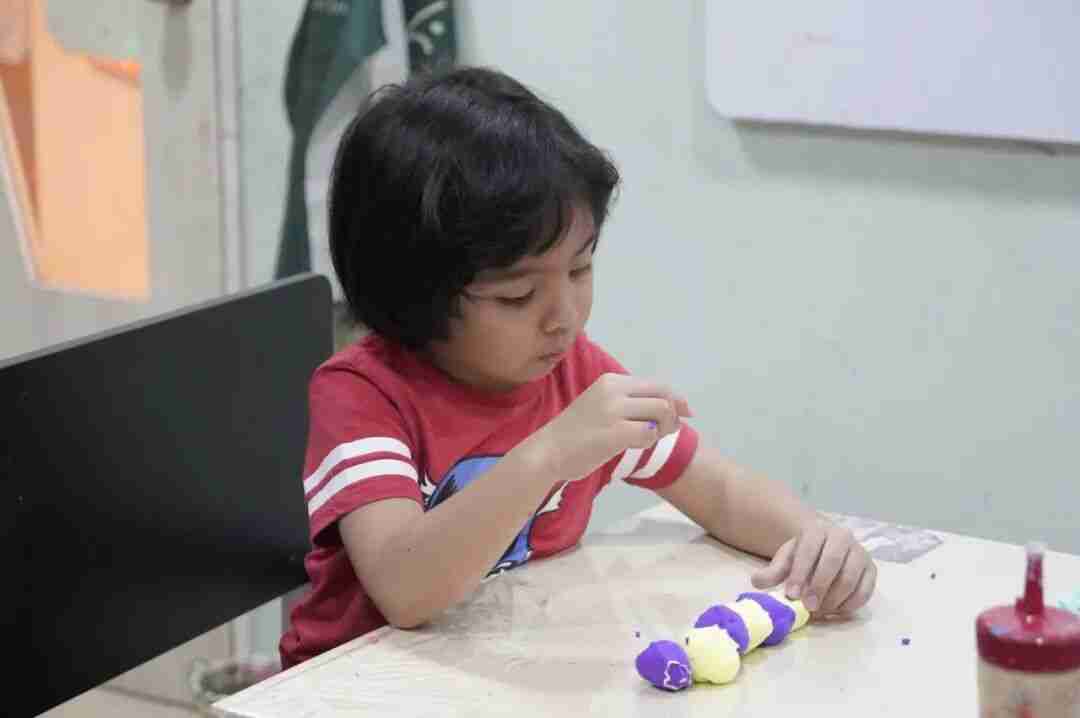 A child expressing themselves through colourful painting during a TreeArt class