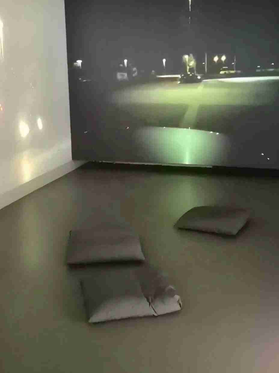 Immersive video projection of a nighttime street scene with floor cushions for seated viewing, part of the Future Perception Lab