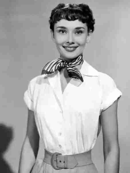 Black-and-white 1950s portrait of a woman with a striped silk scarf tied at her neck