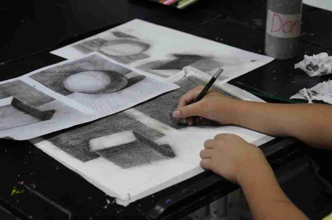 A child concentrating quietly on a drawing during a TreeArt class
