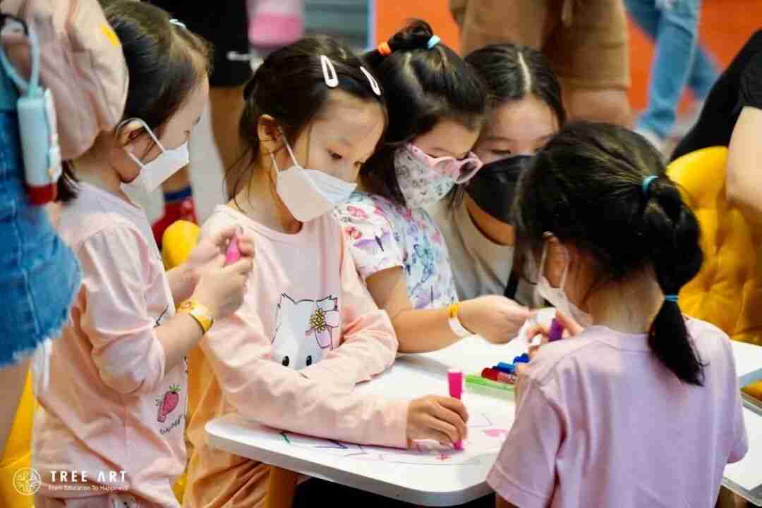 Young children at a TREE ART studio drawing together with markers around a table