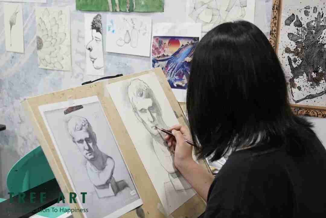 Student patiently refining the details of a drawing