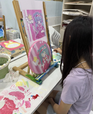 TreeArt student painting a colorful character illustration on an easel