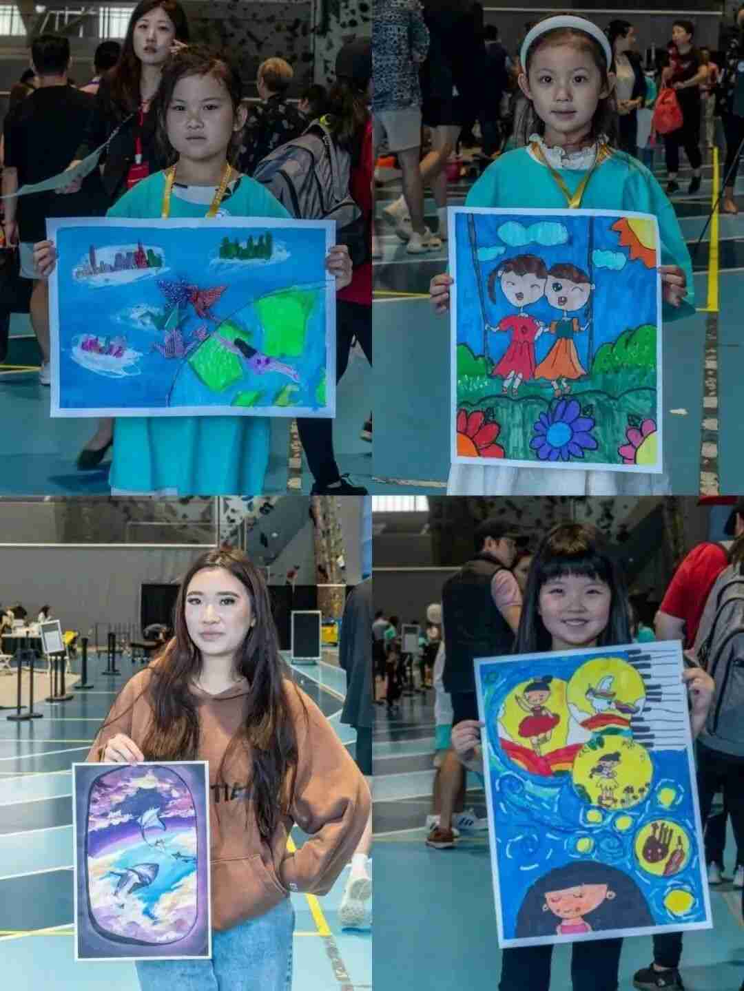 Four young participants holding up their finished paintings at the competition venue