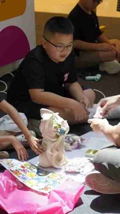 Child sculpting a clay figure at an ART TECH creative workshop
