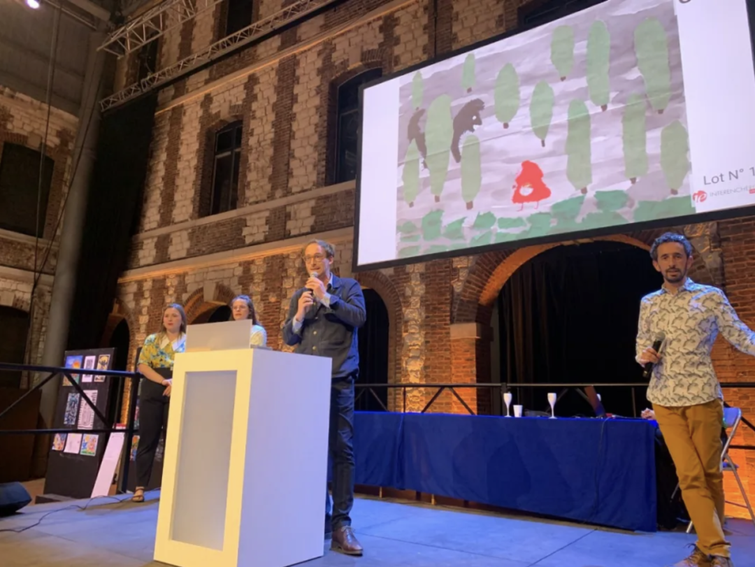 A host presenting a winning fairy-tale-themed artwork on the big screen during the award ceremony
