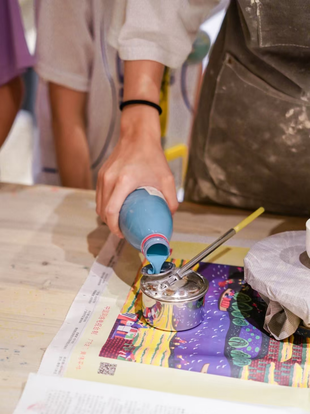 Child applying glaze to a ceramic piece by hand