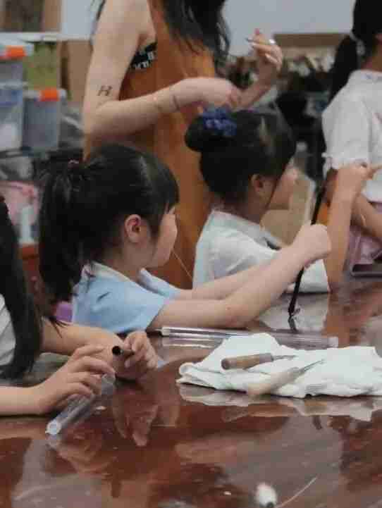 Children learning brush-making steps at the workshop
