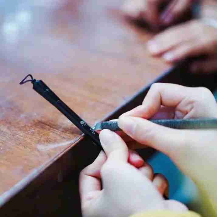 Craftsman demonstrating one of the many steps in making a writing brush