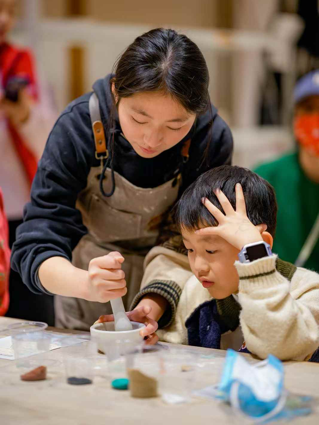 Child hand-shaping a clay cup during the ceramic forming course