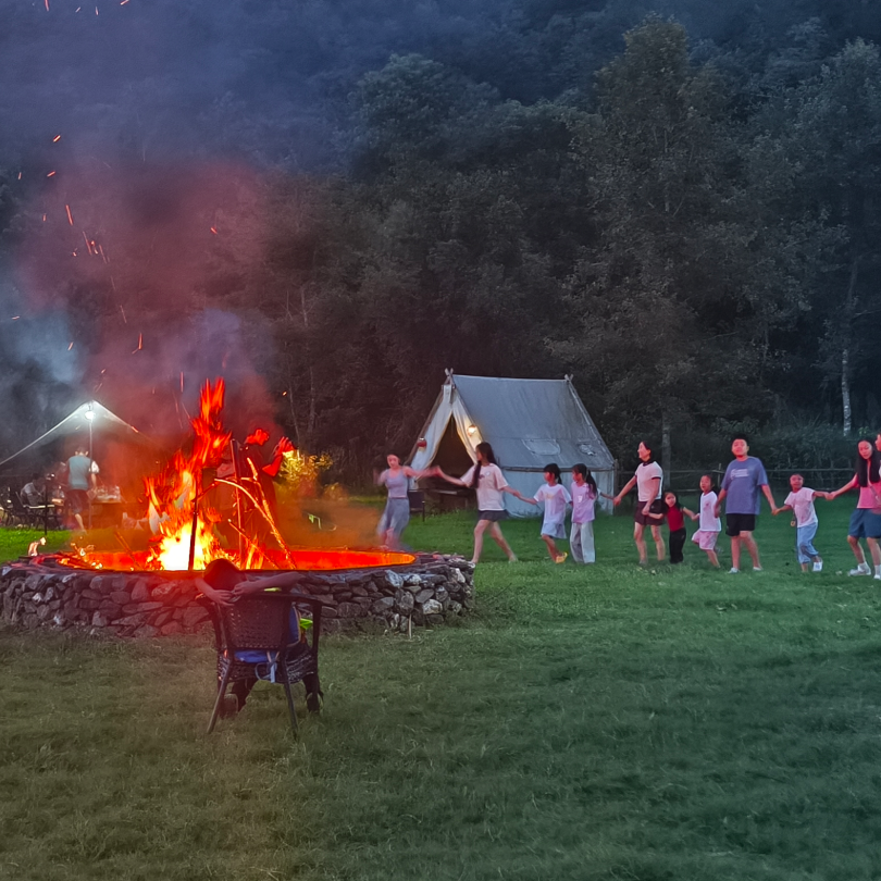Fireworks lighting up the night sky above the bonfire celebration