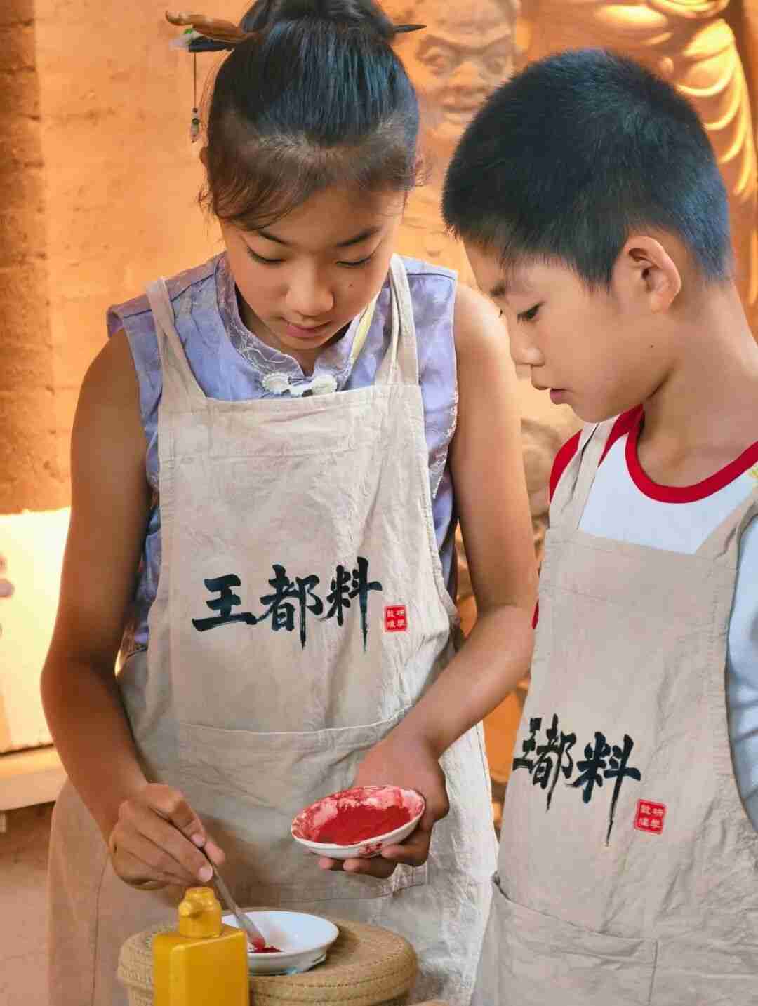 Children mixing pigments with glue for mural copying