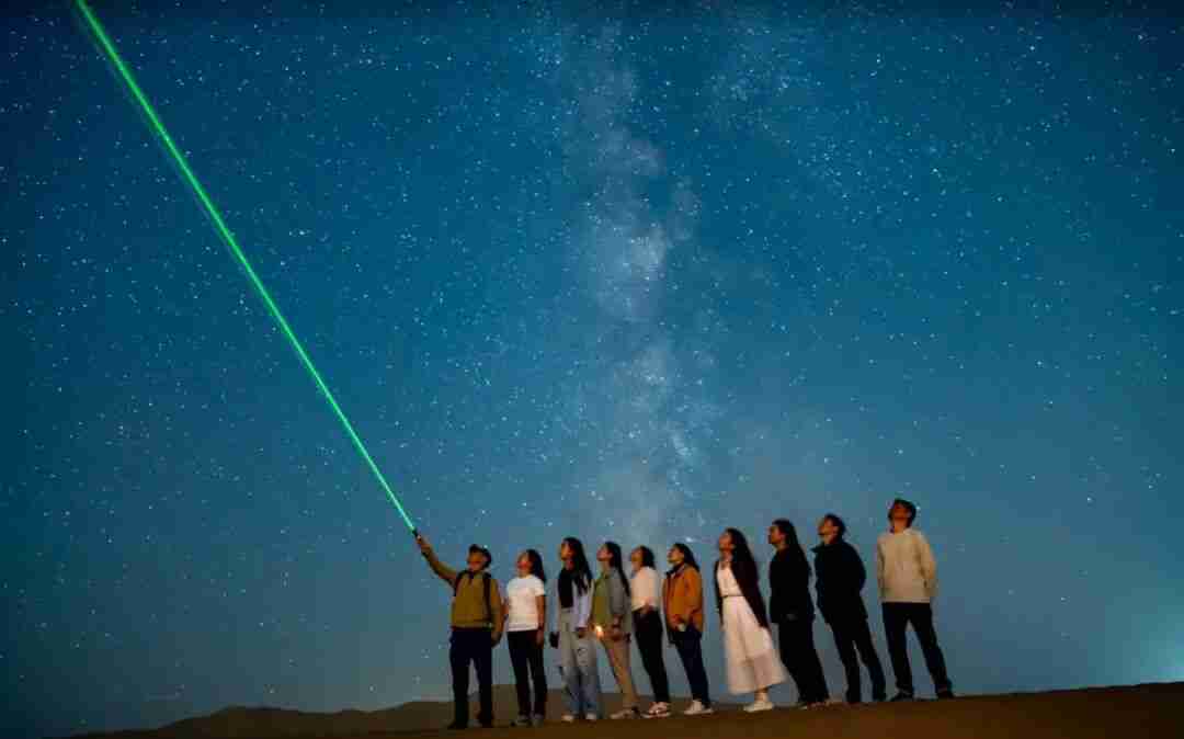 Children stargazing in the Dunhuang desert at night