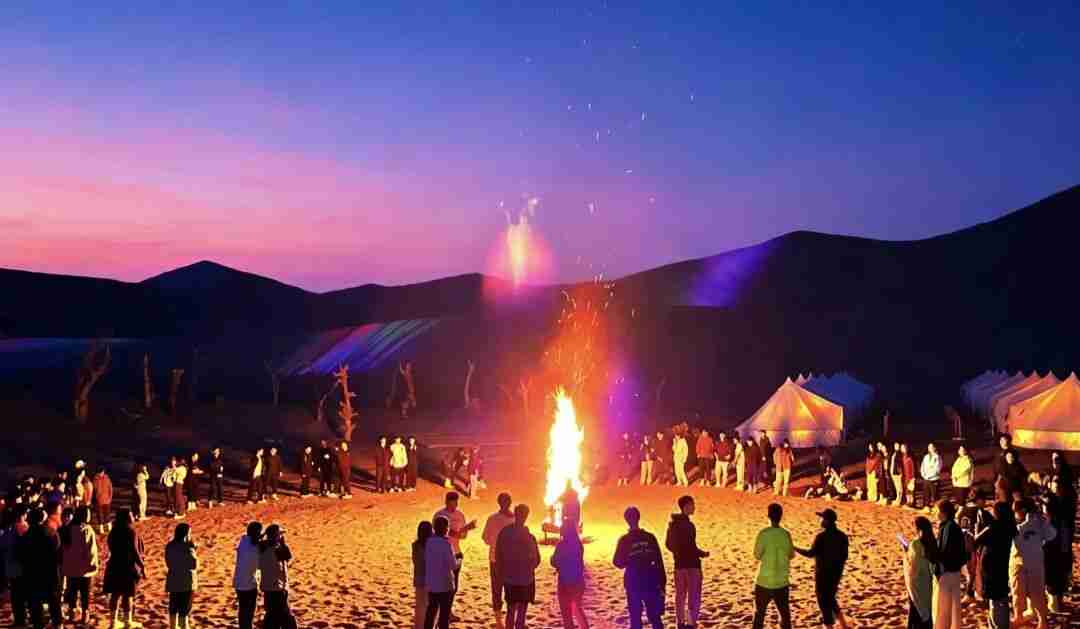 Children enjoying a desert banquet at sunset near Mingsha Mountain