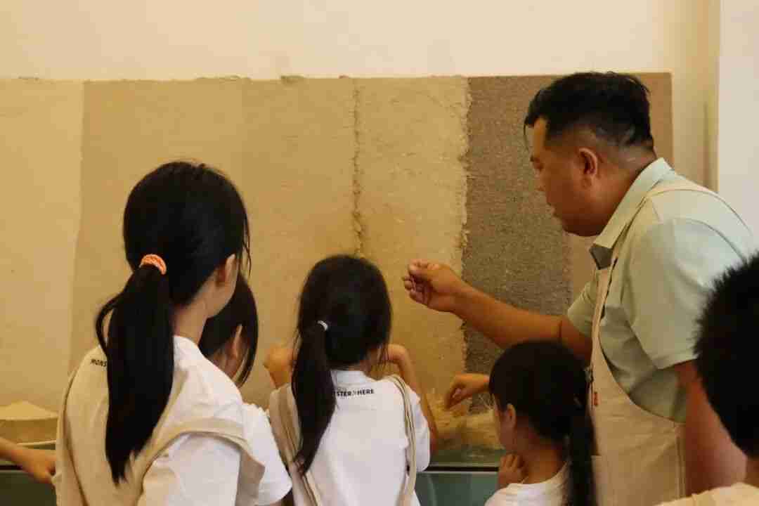 Children sifting sand to remove impurities for the ground layer