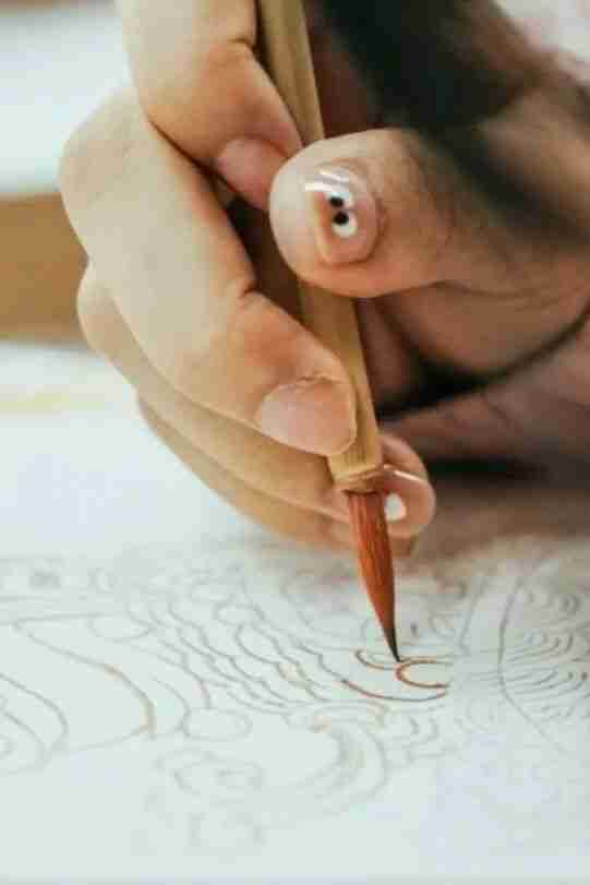 A student line-drawing a Dunhuang mural design