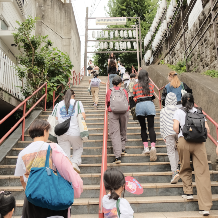 The group climbing the staircase in front of Suga Shrine, the setting from the film Your Name