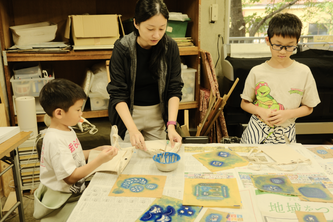 Close-up of a child's hands blending colours in the Kyo-Yuzen dyeing process