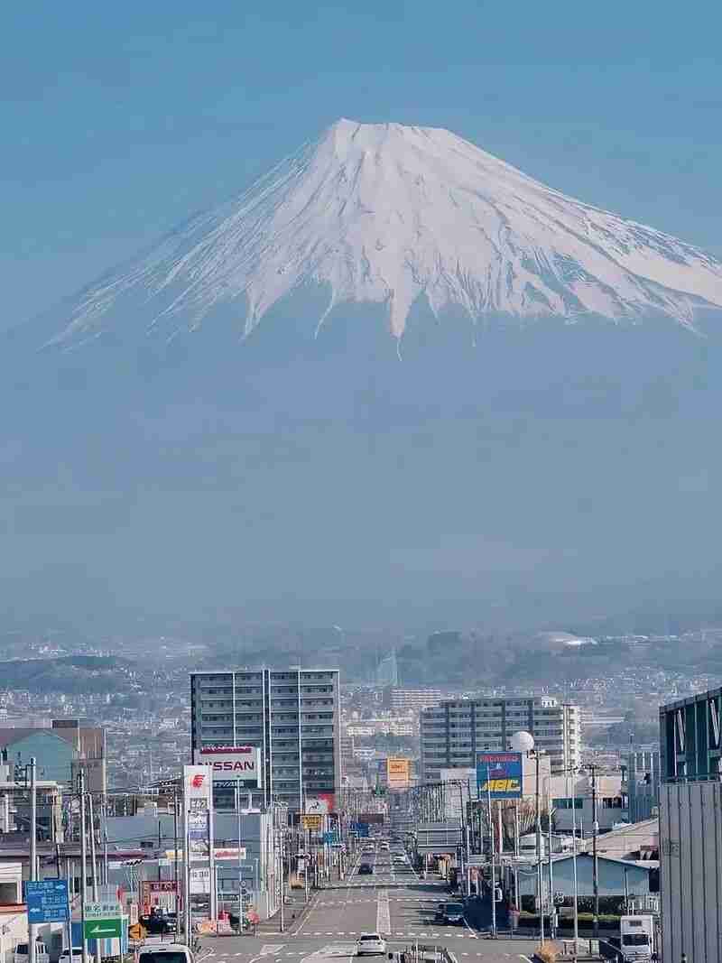 Snow-capped Mount Fuji rising above a Japanese city street