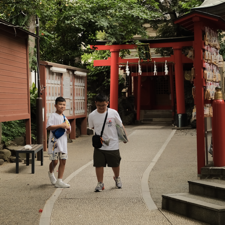 A child posing on the steps of Suga Shrine, the iconic location from Your Name