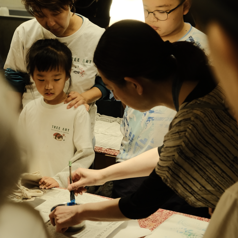 A child learning the traditional Kyo-Yuzen fabric dyeing technique